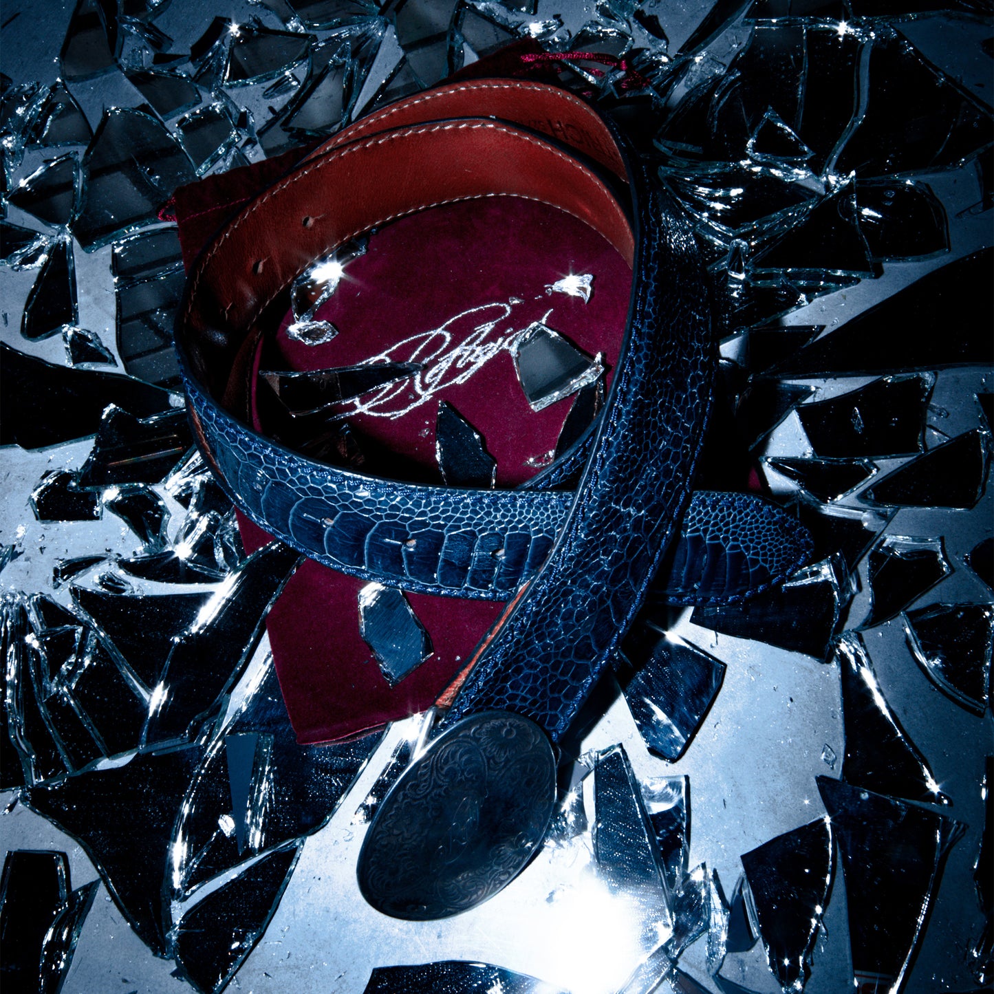 Navy blue ostrich leather belt styled with burgundy velvet bag and glass – Reflejos Smash & Grab